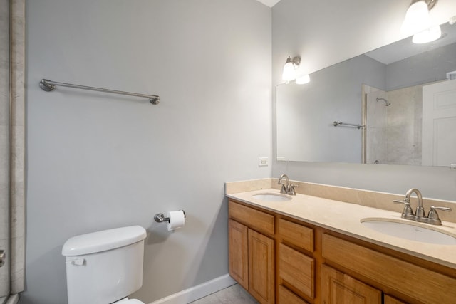 full bath with a sink, a tile shower, toilet, and double vanity