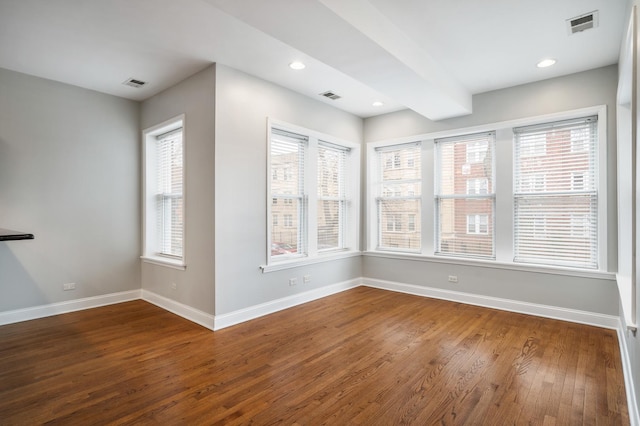 interior space with baseboards, visible vents, and wood finished floors