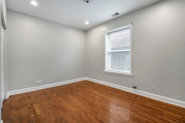 spare room featuring baseboards, visible vents, wood finished floors, and recessed lighting