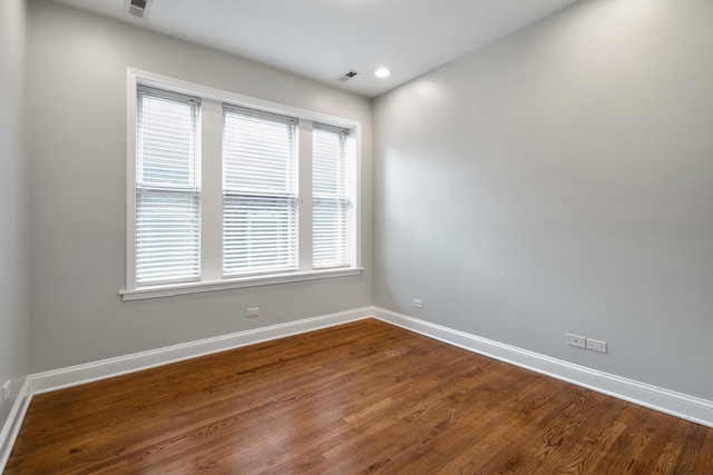 unfurnished room with visible vents, baseboards, dark wood finished floors, and recessed lighting