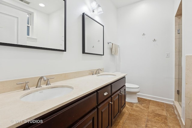 bathroom featuring a sink, baseboards, toilet, and a shower stall