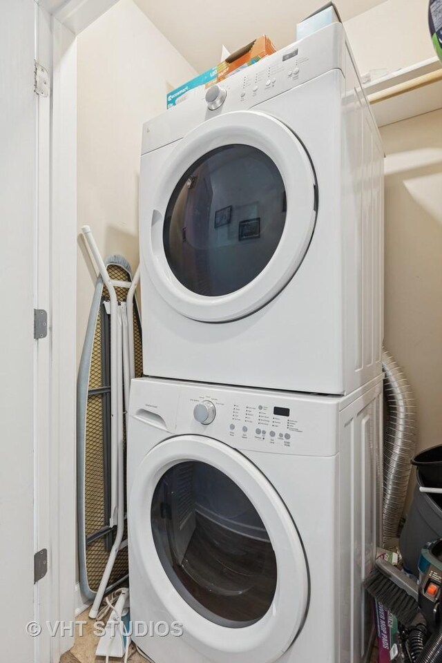 washroom featuring stacked washer and dryer and laundry area