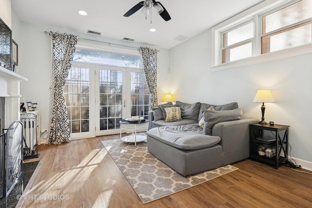 living room featuring visible vents, wood finished floors, and a fireplace