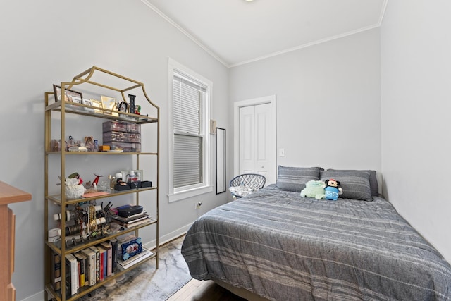 bedroom with baseboards, crown molding, and wood finished floors