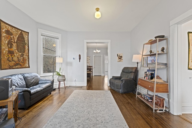 sitting room with dark wood-style floors, baseboards, and a chandelier