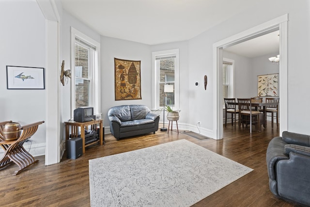 living area with baseboards and dark wood-style flooring