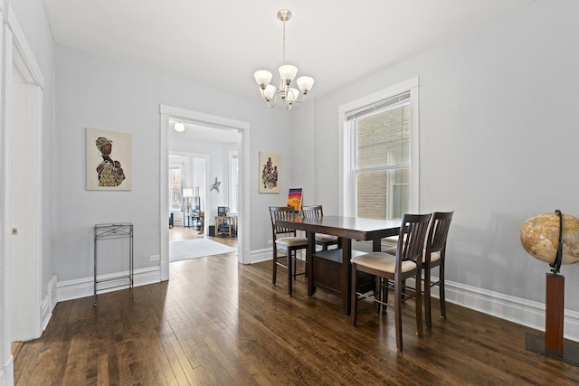 dining room featuring hardwood / wood-style flooring, baseboards, and an inviting chandelier