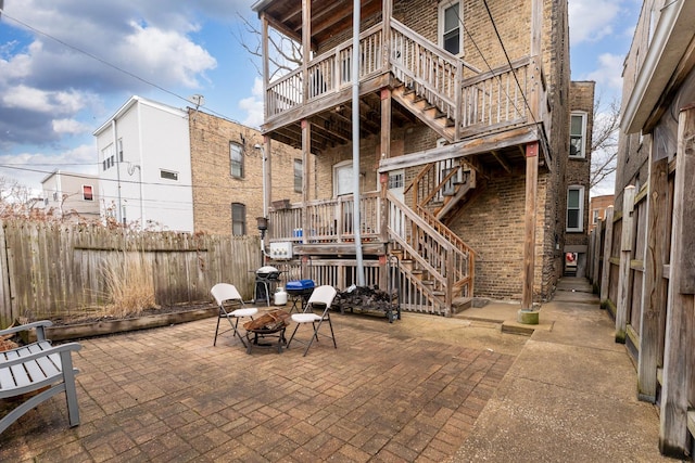 view of patio / terrace with a fire pit, fence, and stairs