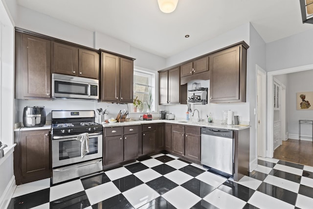 kitchen with appliances with stainless steel finishes, light countertops, and tile patterned floors