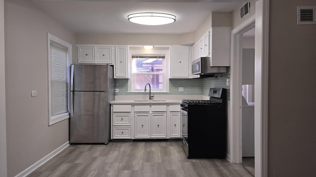 kitchen featuring visible vents, white cabinets, appliances with stainless steel finishes, and a sink