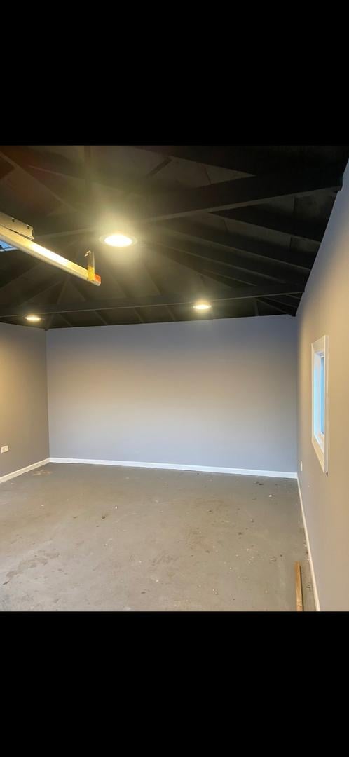 below grade area with baseboards and a garage