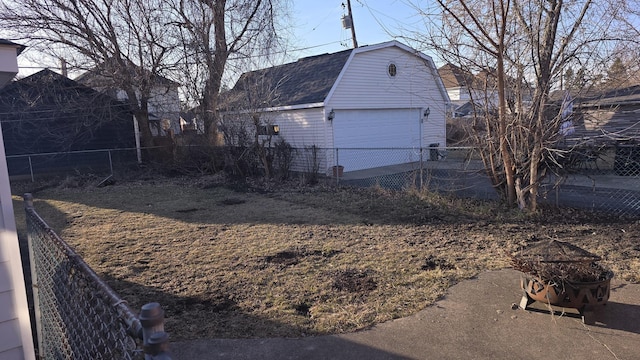 exterior space with a gambrel roof, fence, an outdoor structure, a shingled roof, and a garage