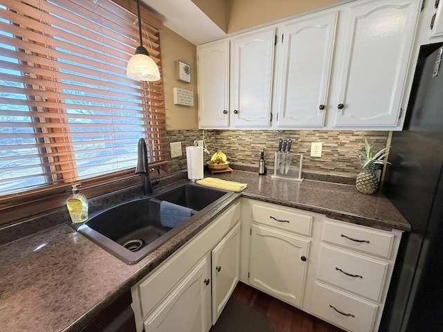 kitchen with white cabinetry, a sink, backsplash, and black appliances