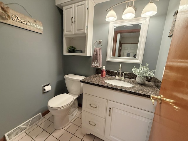 bathroom with toilet, vanity, visible vents, and tile patterned floors