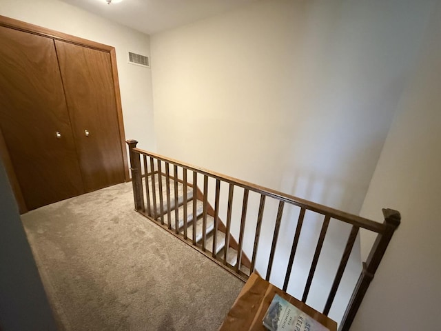 stairway featuring carpet floors and visible vents