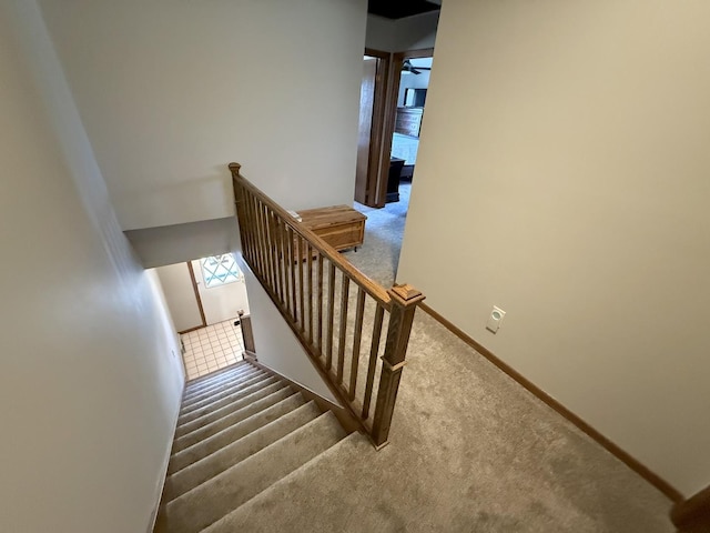 stairs featuring carpet floors and baseboards