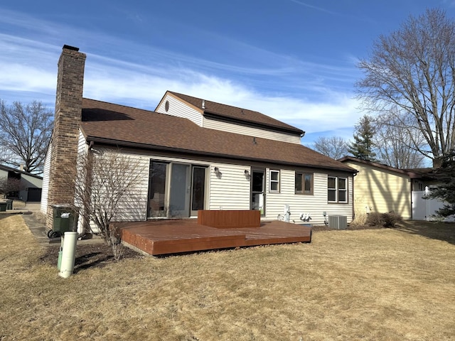 rear view of property featuring a chimney, central AC, a lawn, and a deck