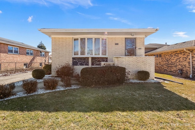 view of front facade featuring a front yard and brick siding