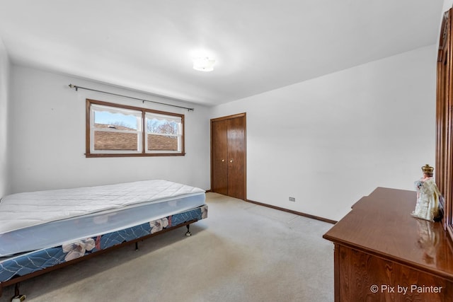 bedroom with light carpet, a closet, and baseboards