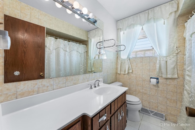 bathroom featuring tile walls, visible vents, toilet, vanity, and tile patterned flooring