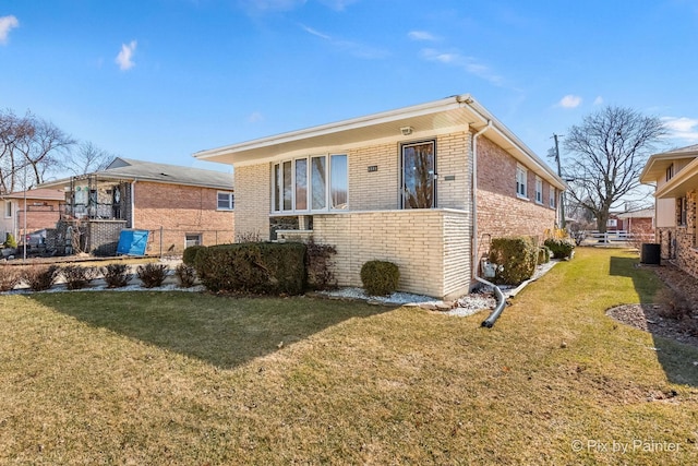 exterior space featuring central AC unit, a lawn, and brick siding