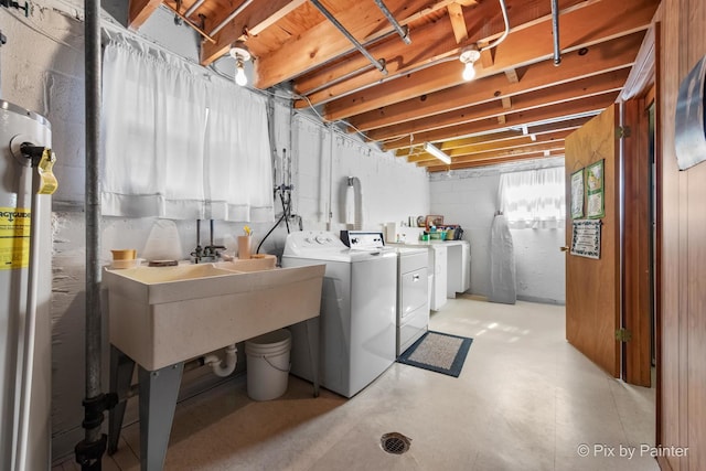 below grade area featuring water heater and independent washer and dryer