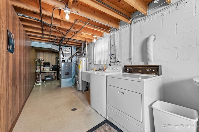 laundry area featuring concrete block wall, heating unit, water heater, separate washer and dryer, and laundry area