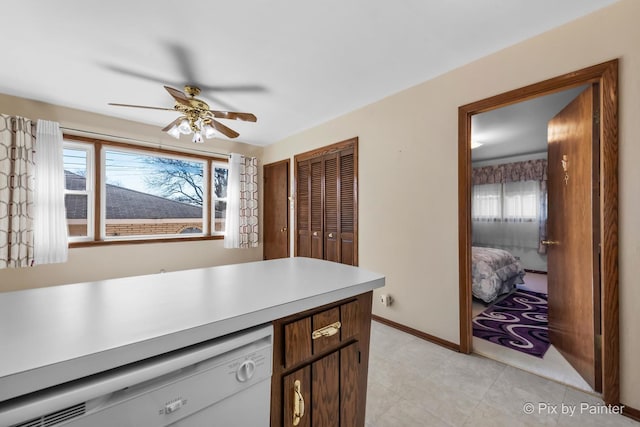 kitchen with dishwasher, light countertops, plenty of natural light, and baseboards