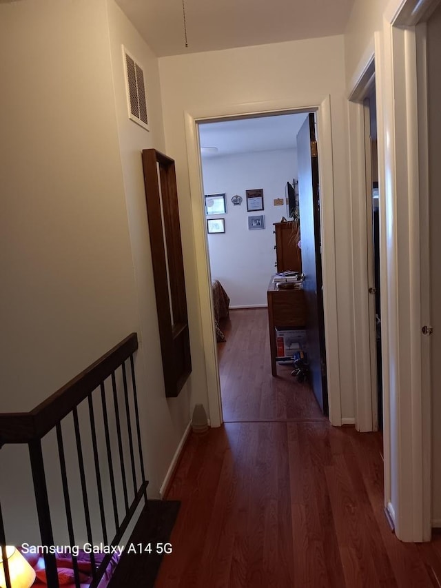 hall featuring visible vents and wood finished floors