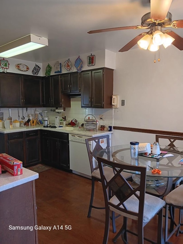 kitchen with light countertops, backsplash, white dishwasher, a sink, and ceiling fan