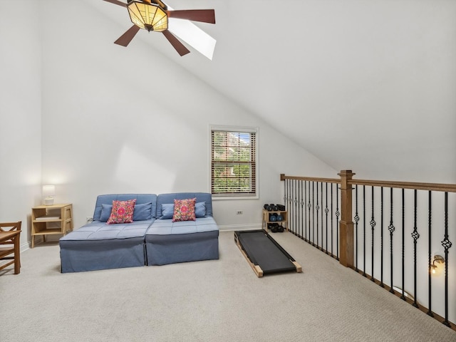 carpeted living room featuring lofted ceiling with skylight, baseboards, and ceiling fan