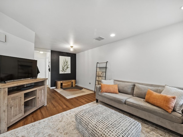 living area with recessed lighting, visible vents, baseboards, and wood finished floors