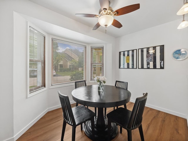 dining space featuring ceiling fan, baseboards, and wood finished floors