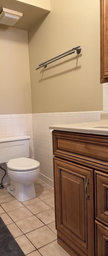 4036 Linden Ave, Western Springs, IL 60558 - bathroom featuring tile patterned floors, a wainscoted wall, toilet, tile walls, and vanity