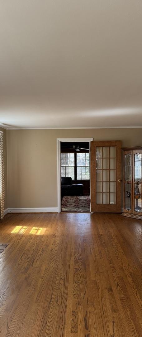 4036 Linden Ave, Western Springs, IL 60558 - unfurnished living room featuring baseboards, wood finished floors, and ornamental molding