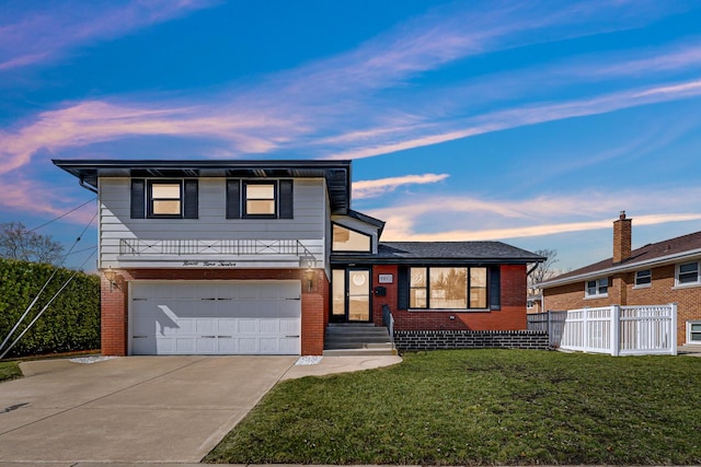 split level home featuring brick siding, concrete driveway, fence, and a lawn