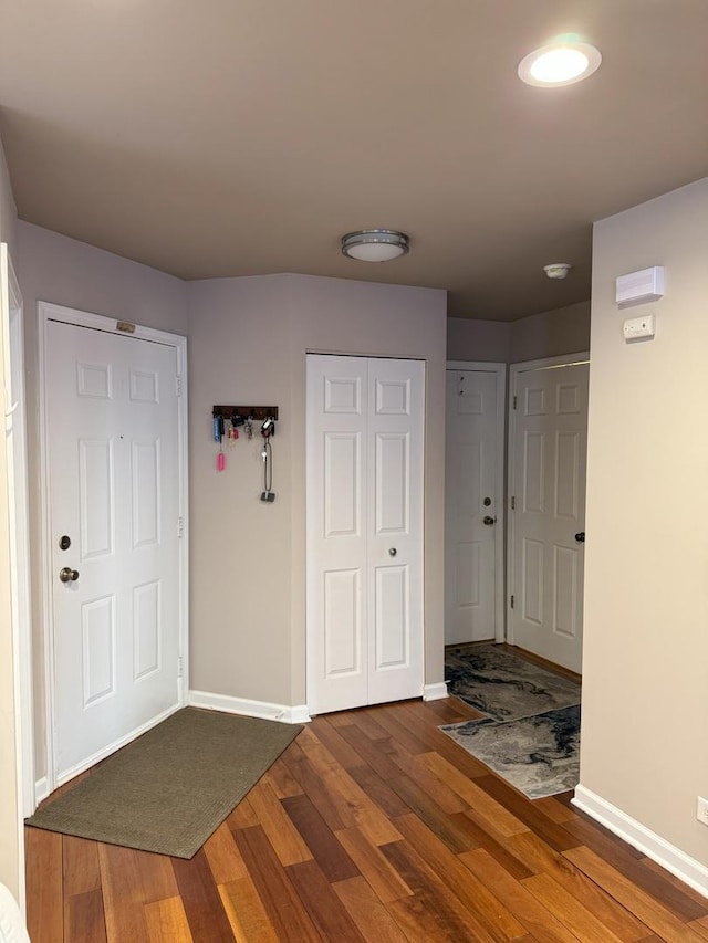 foyer featuring baseboards and wood finished floors