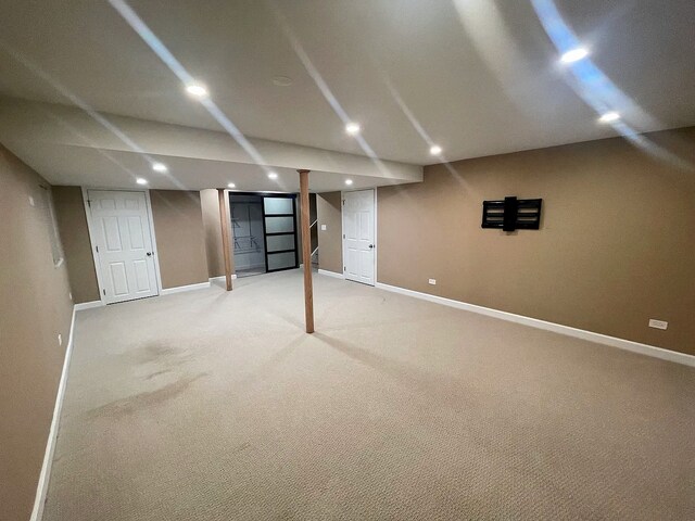 finished below grade area with light carpet, recessed lighting, and baseboards