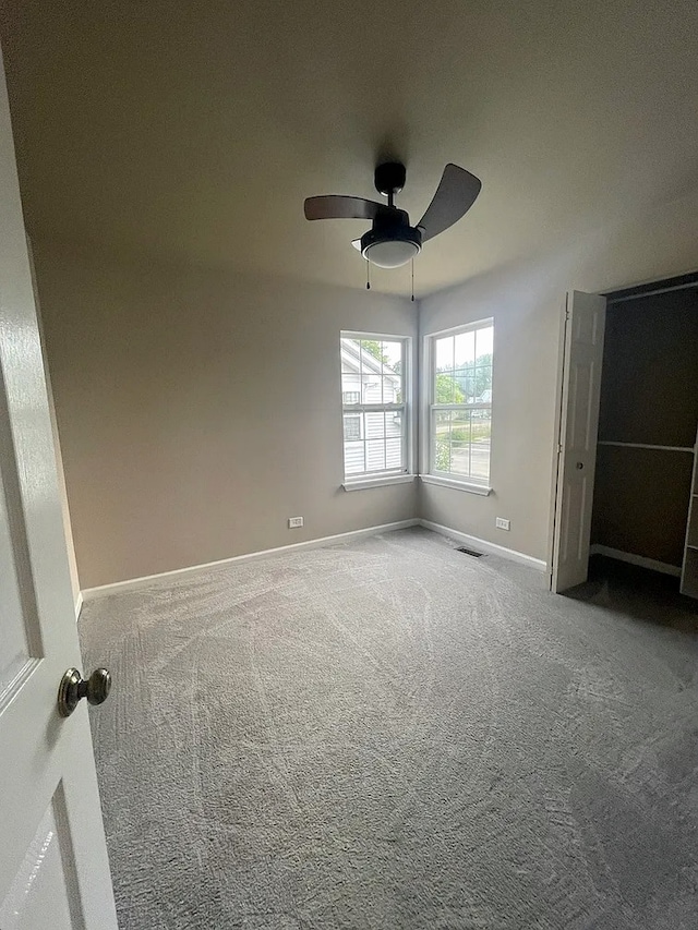 unfurnished bedroom featuring a ceiling fan, carpet, visible vents, and baseboards