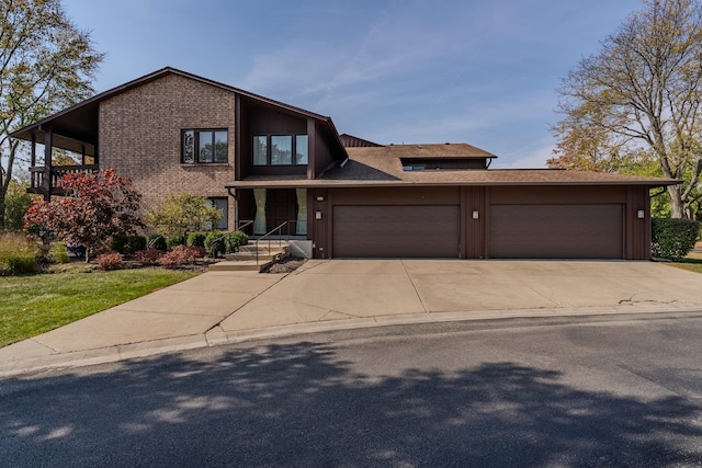 view of front of house with a garage, concrete driveway, and brick siding