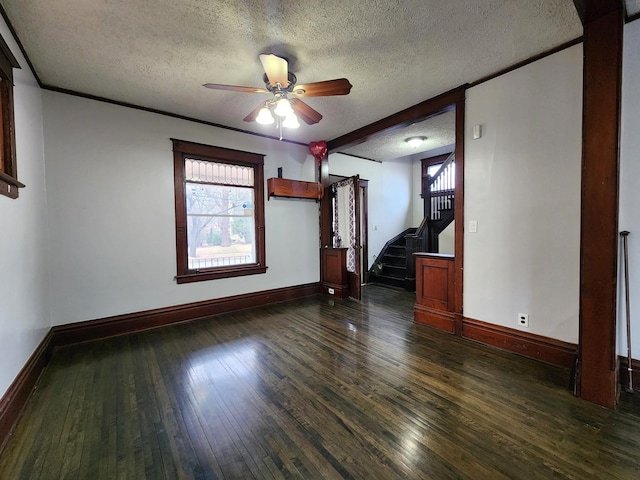 spare room featuring dark wood-style floors, stairway, a textured ceiling, and baseboards