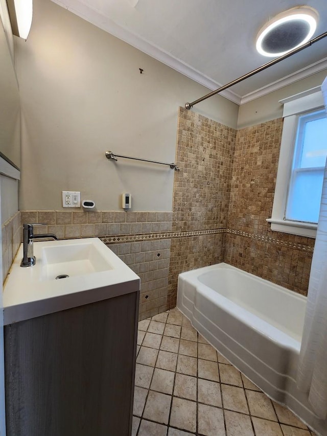 bathroom with tile patterned flooring, shower / bath combination, vanity, tile walls, and crown molding