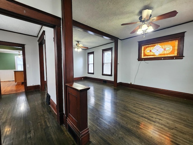 unfurnished room featuring dark wood finished floors, a textured ceiling, and baseboards