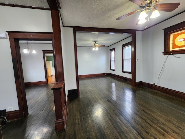 empty room featuring baseboards, a ceiling fan, hardwood / wood-style flooring, ornamental molding, and a textured ceiling