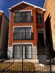 view of front of house featuring a fenced front yard and a balcony