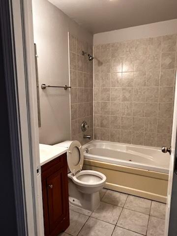 full bathroom featuring toilet, tile patterned flooring, washtub / shower combination, and vanity