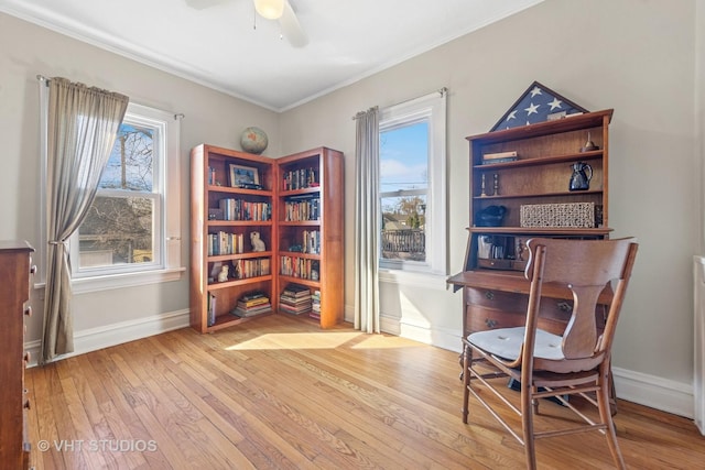 living area with baseboards, crown molding, ceiling fan, and hardwood / wood-style floors