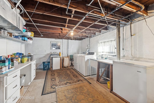 clothes washing area featuring a sink, laundry area, and washer and clothes dryer