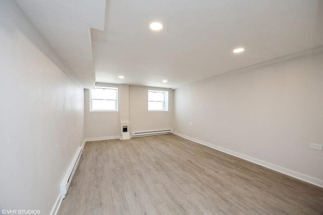 spare room featuring recessed lighting, a baseboard heating unit, baseboards, light wood-style floors, and baseboard heating