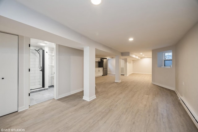 basement with baseboards, a baseboard radiator, freestanding refrigerator, light wood-type flooring, and recessed lighting